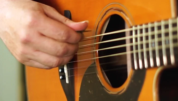 Apply more pressure to the back of the pick than the front, rolling your thumb to achieve this. This creates a smoother strumming action.