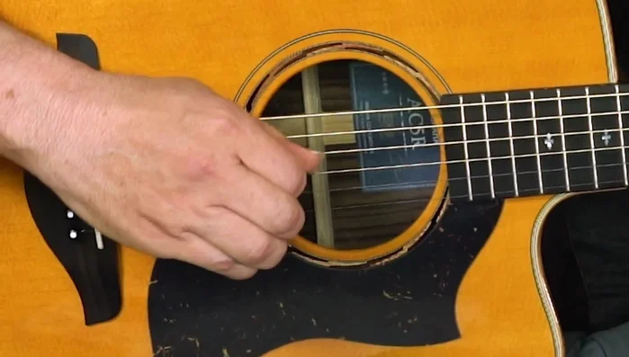 Apply more pressure to the back of the pick than the front, rolling your thumb to achieve this. This creates a smoother strumming action.
