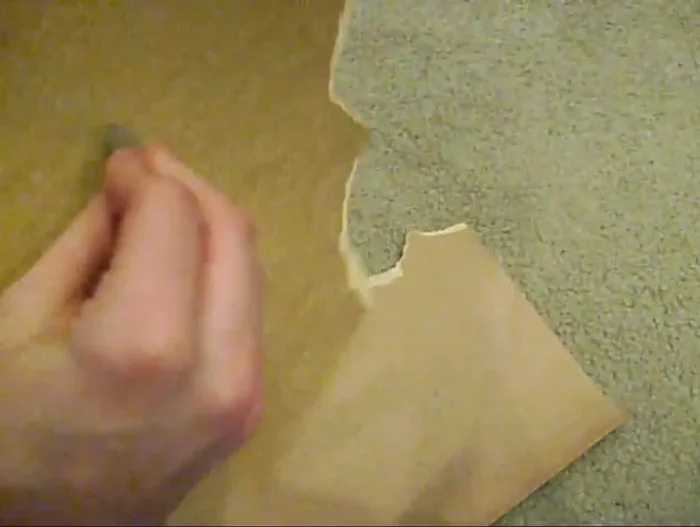 Sand down the edges of the cut-out guitar pick using coarse and then fine sandpaper, smoothing it to the desired shape and creating a smooth, playable edge.