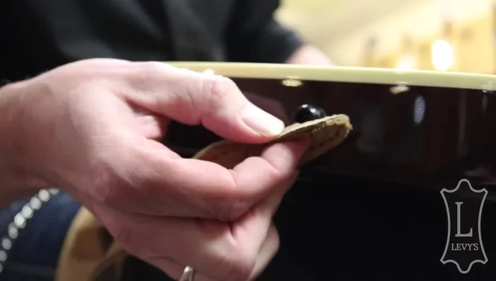 Push the strap pin into the hole and rotate it counterclockwise.