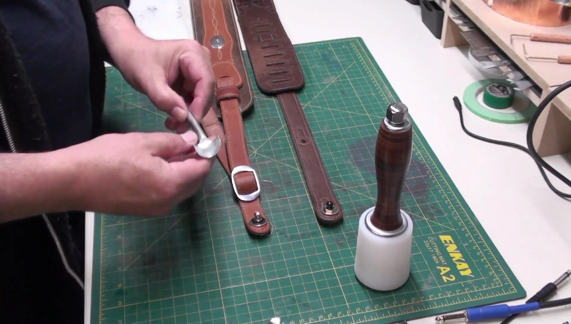 Using a leather punch to create a rounded end on the strap.