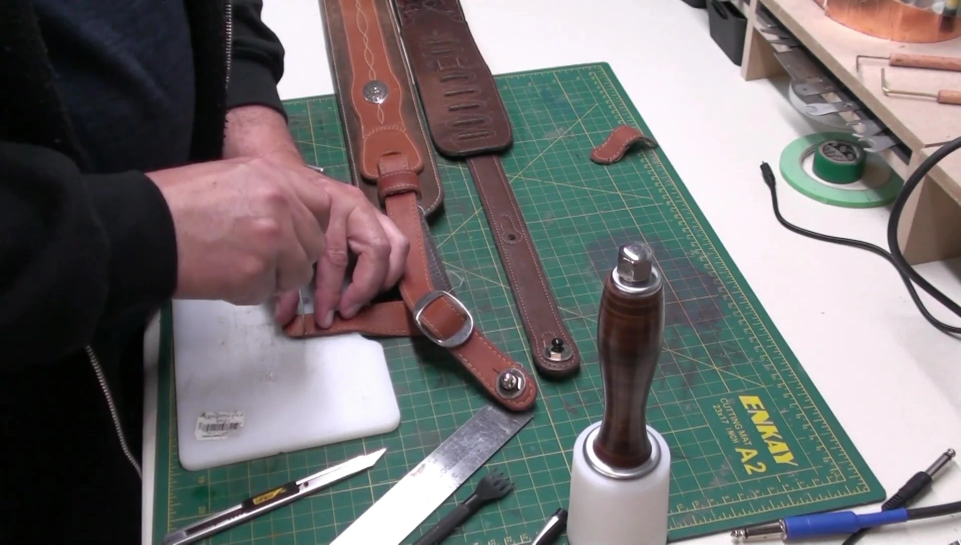 Using a leather awl to create new stitch holes.