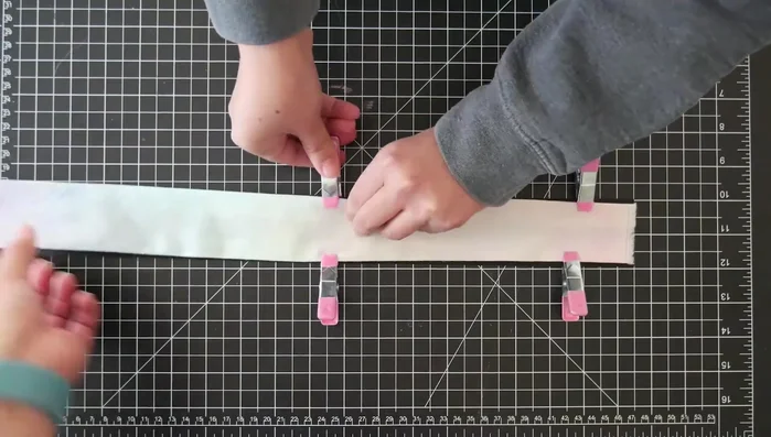 Clip and sew the fabric onto the nylon strap (Note: The creators found clips unhelpful and recommend sewing directly without them).