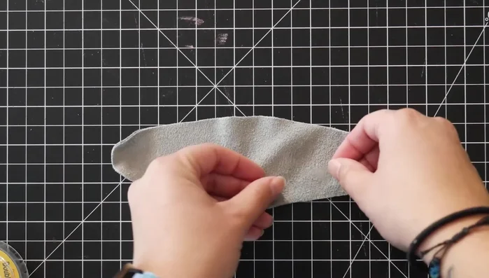 Attach the D-ring to the large leather piece using double-sided tape, then sew.