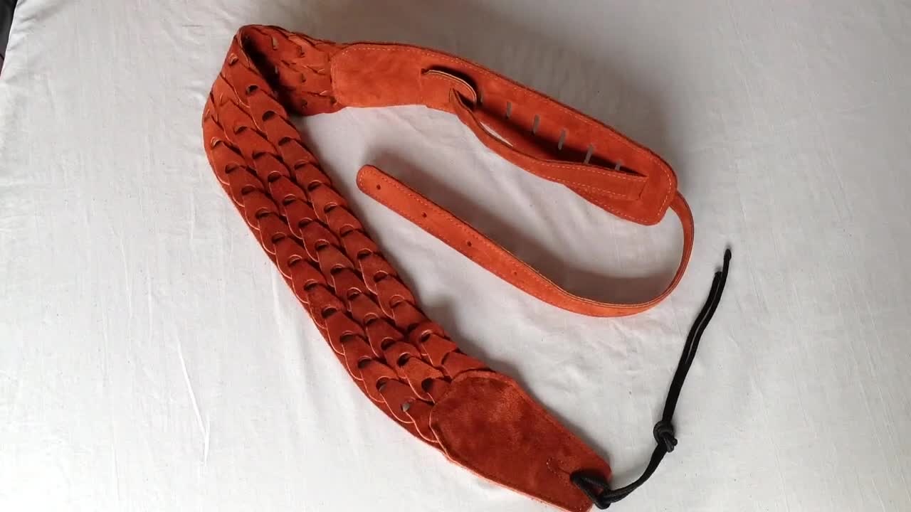 Close-up of the rust-colored suede guitar strap.