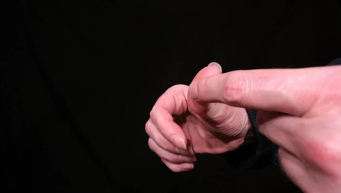 Position the base of your thumb over the width of the pick, ensuring only a small portion of the pick is visible.