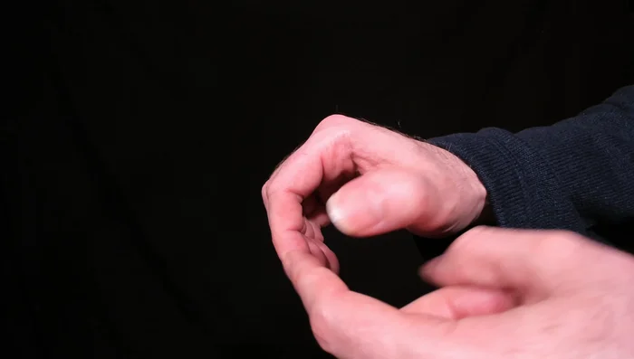 Position the base of your thumb over the width of the pick, ensuring only a small portion of the pick is visible.