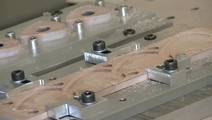 Flip the wood over again, secure it in the jig, and carve the bottom side of the picks.