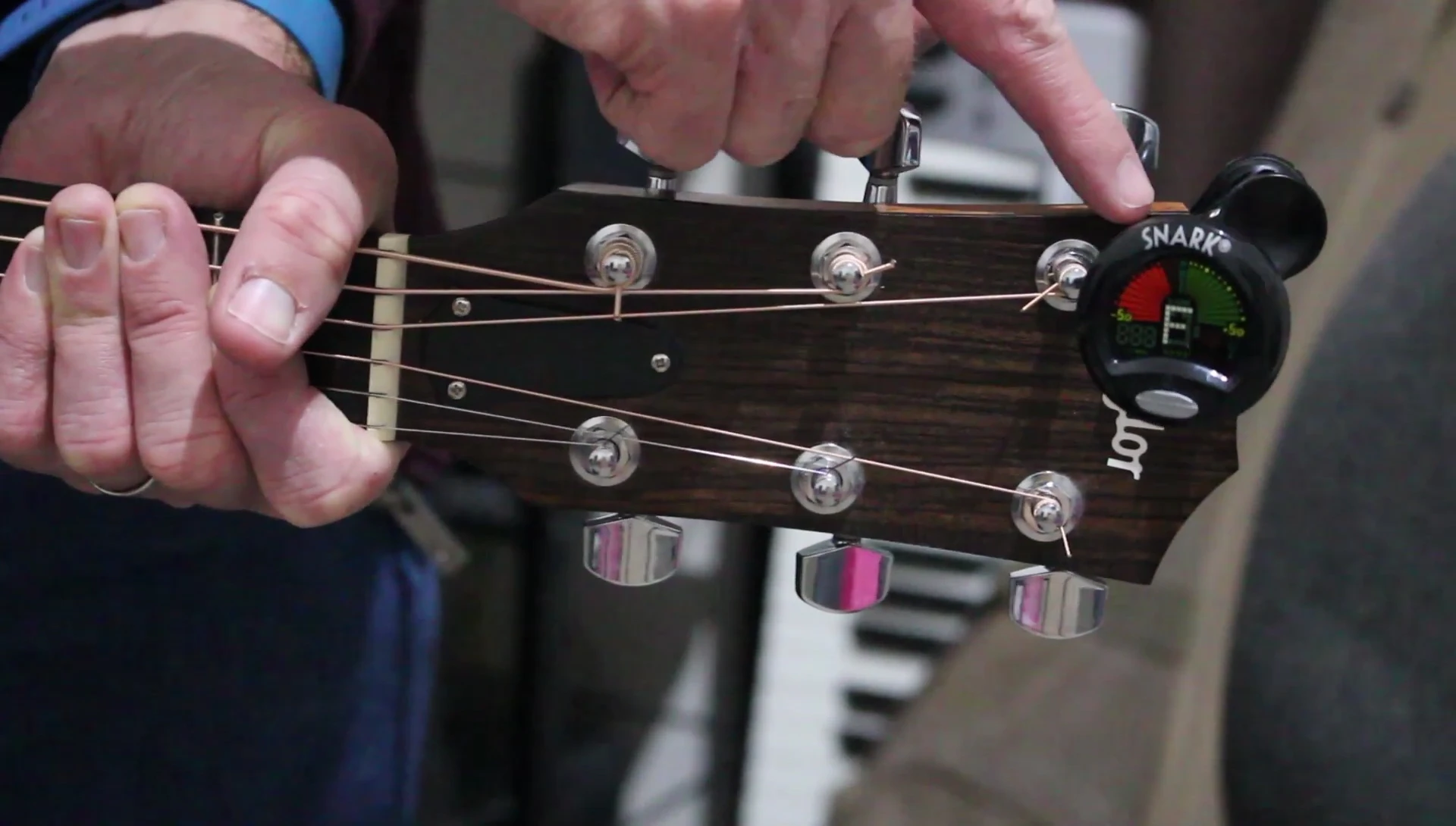 The tuner is highlighted on the guitar headstock.