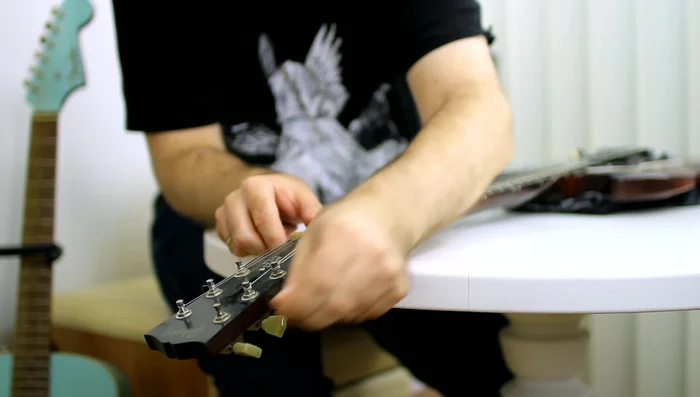 Remove the strings from the guitar. Avoid cutting them to save as spares.