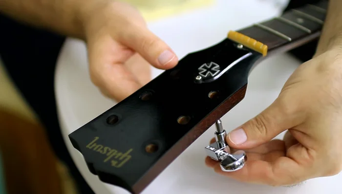 Secure the new tuning machines using screws.