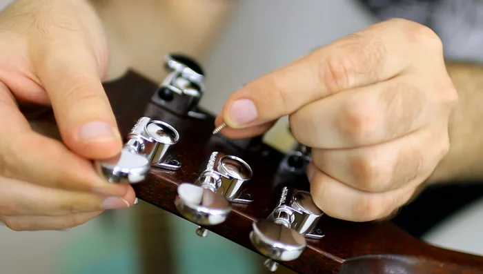 Secure the new tuning machines using screws.