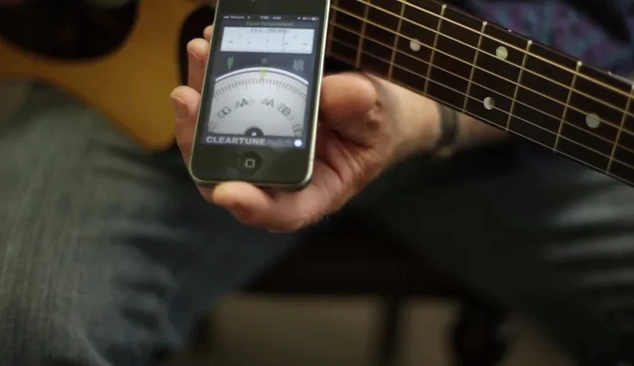 Adjust the tuning pegs based on the app's visual and/or auditory feedback.