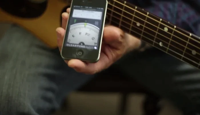 Adjust the tuning pegs based on the app's visual and/or auditory feedback.