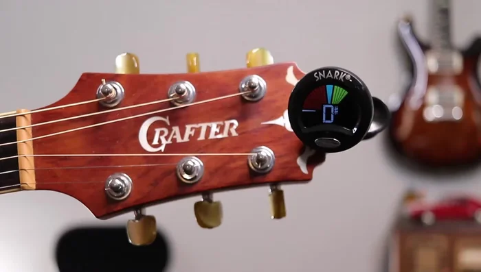 Start with the high E string. Pluck the string and adjust the tuning peg (clockwise to raise pitch, counterclockwise to lower) until the tuner displays the correct note (E) without any sharps or flats.