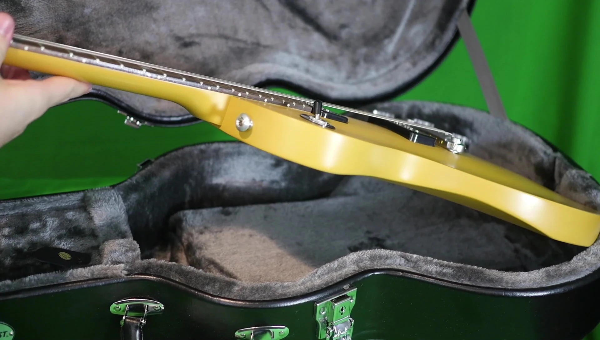 A Les Paul Special-style guitar being placed inside the case.