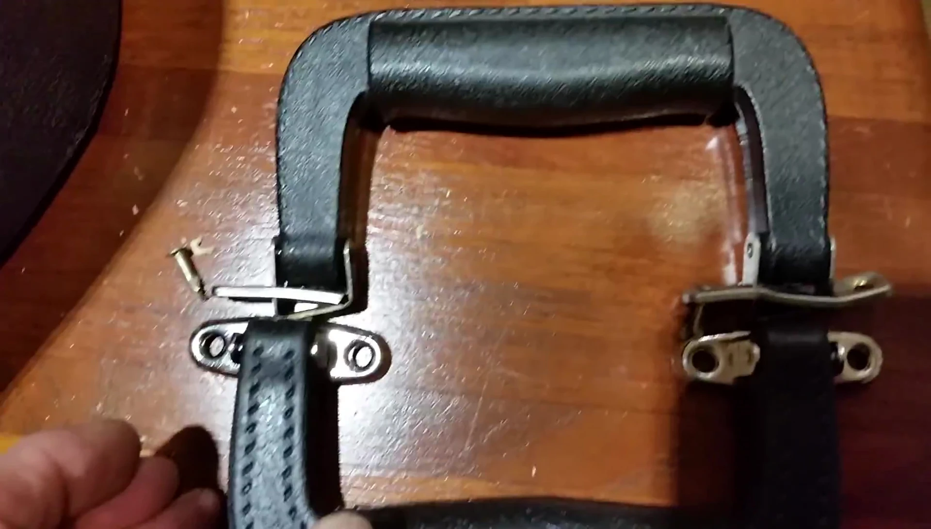 The speaker is modifying the handle using pliers and a screwdriver.