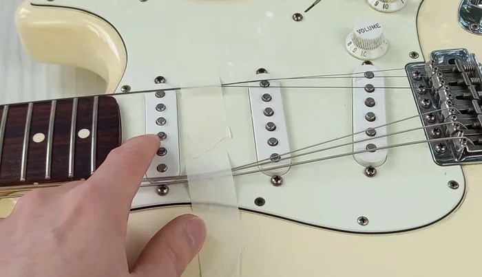 Remove guitar strings for better access.