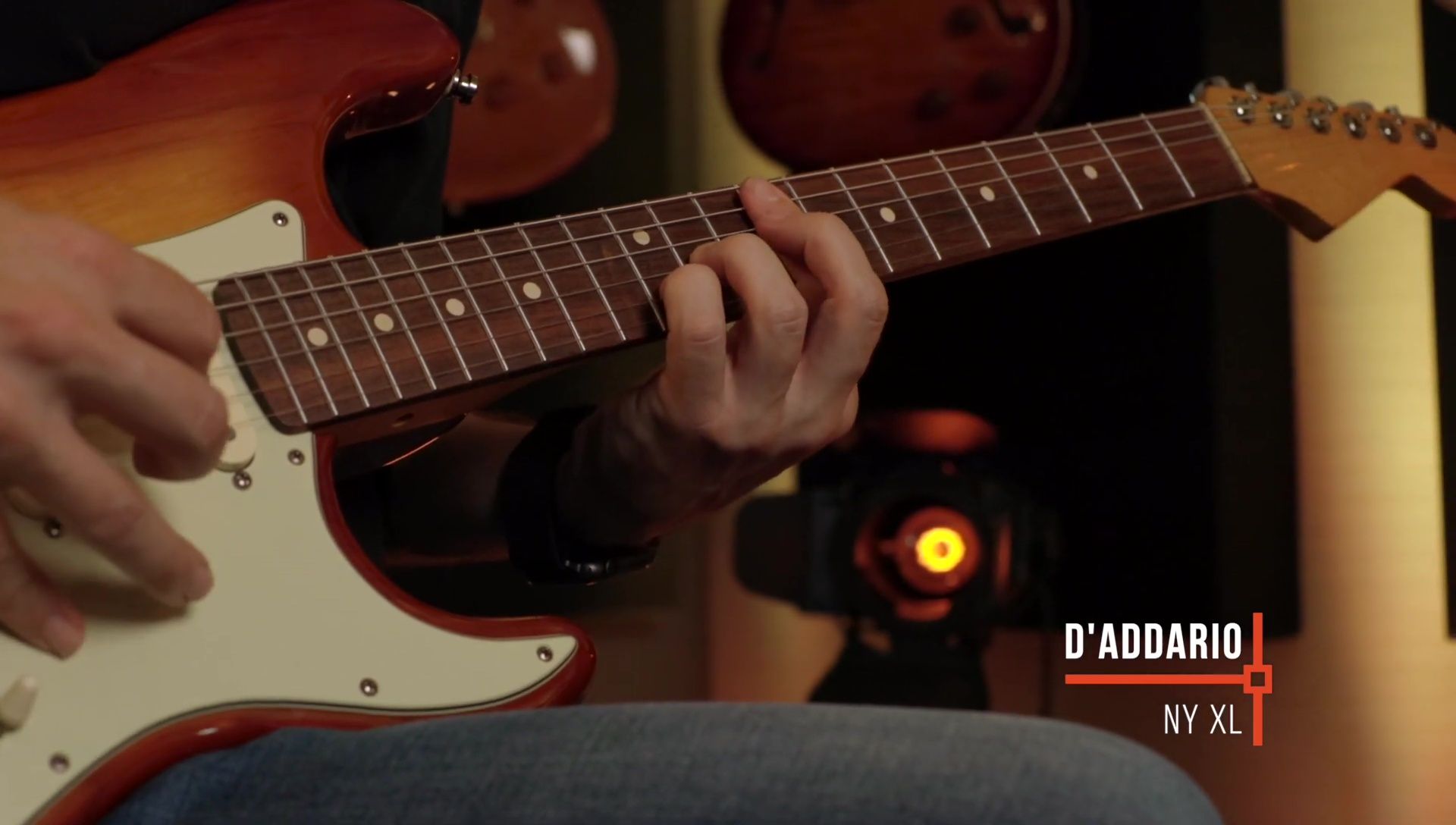 The presenter demonstrating playing of different strings