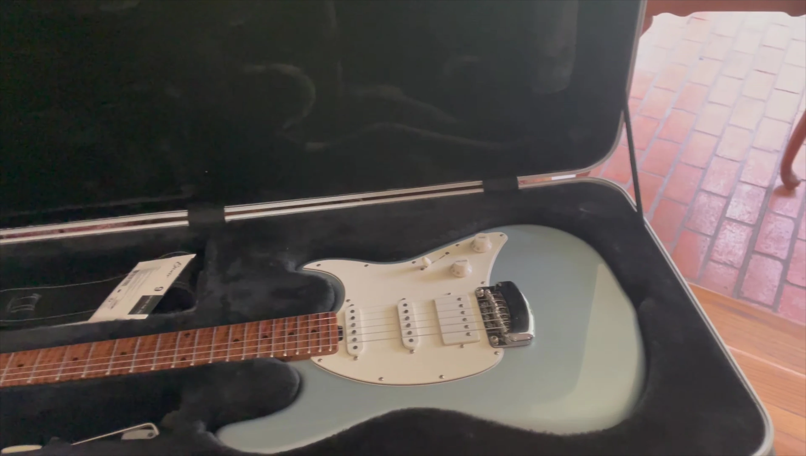 The speaker playing an Ernie Ball Music Man guitar.