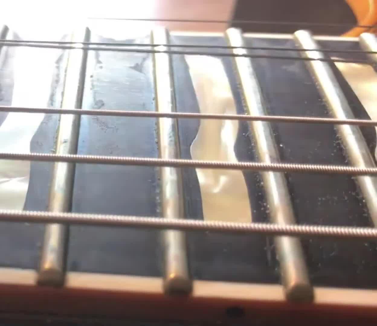 Image highlighting the grime on the fretboard alongside the worn Ernie Ball strings.