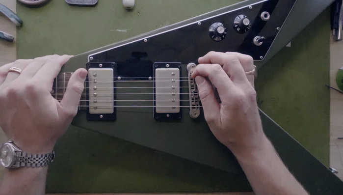 Slacken the string and check the saddle for burrs using your fingernail.