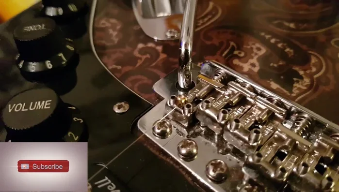 Hold the ball end down with your finger until the string's downward force holds it in place.