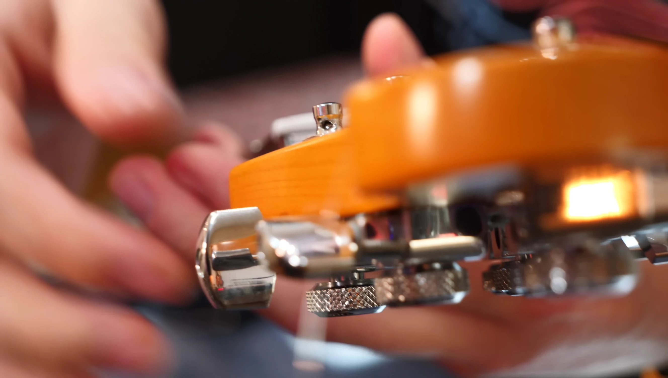 The guitarist struggling to tune the thin string due to lack of tension