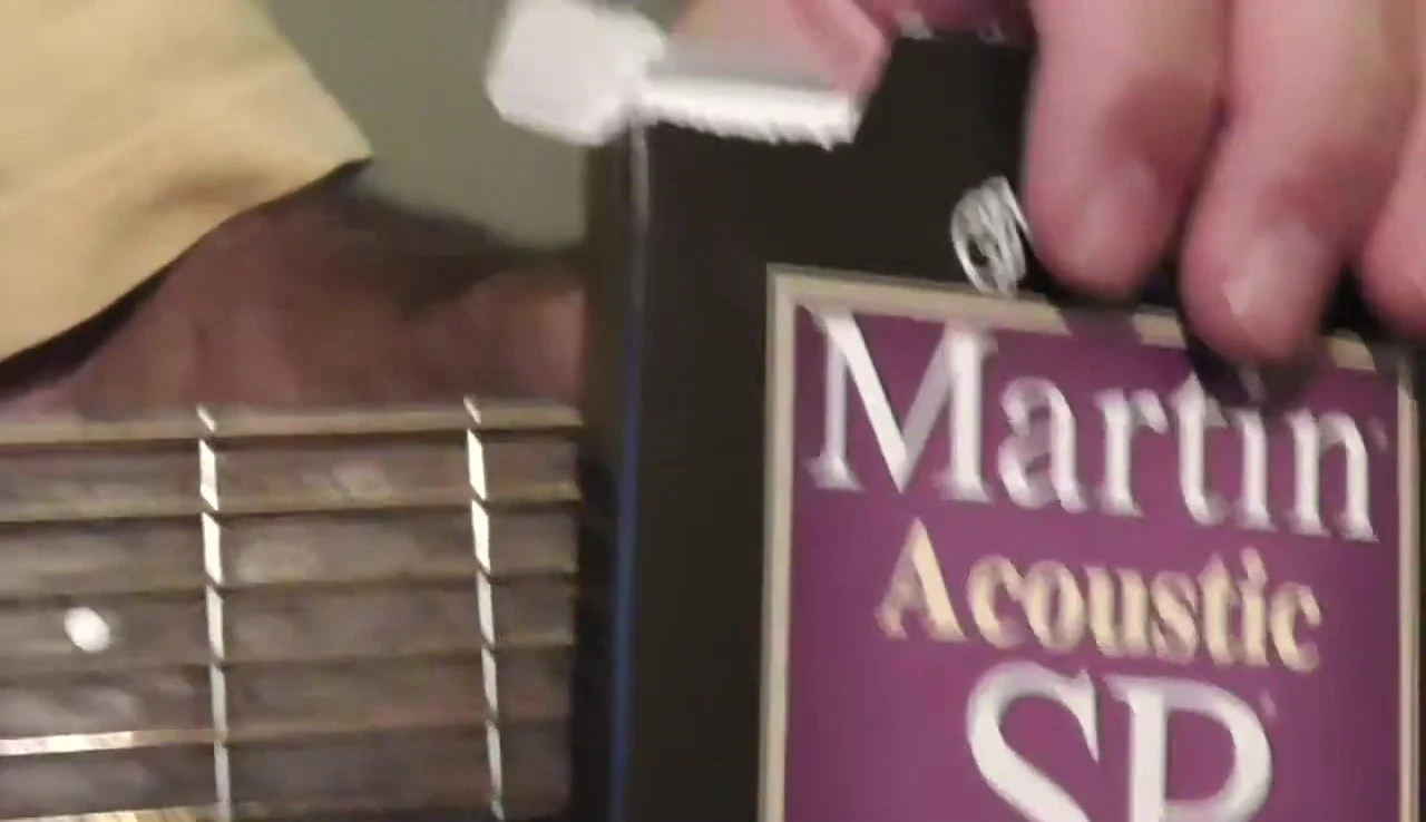 Close-up of the reviewer's hands playing the sixth string.