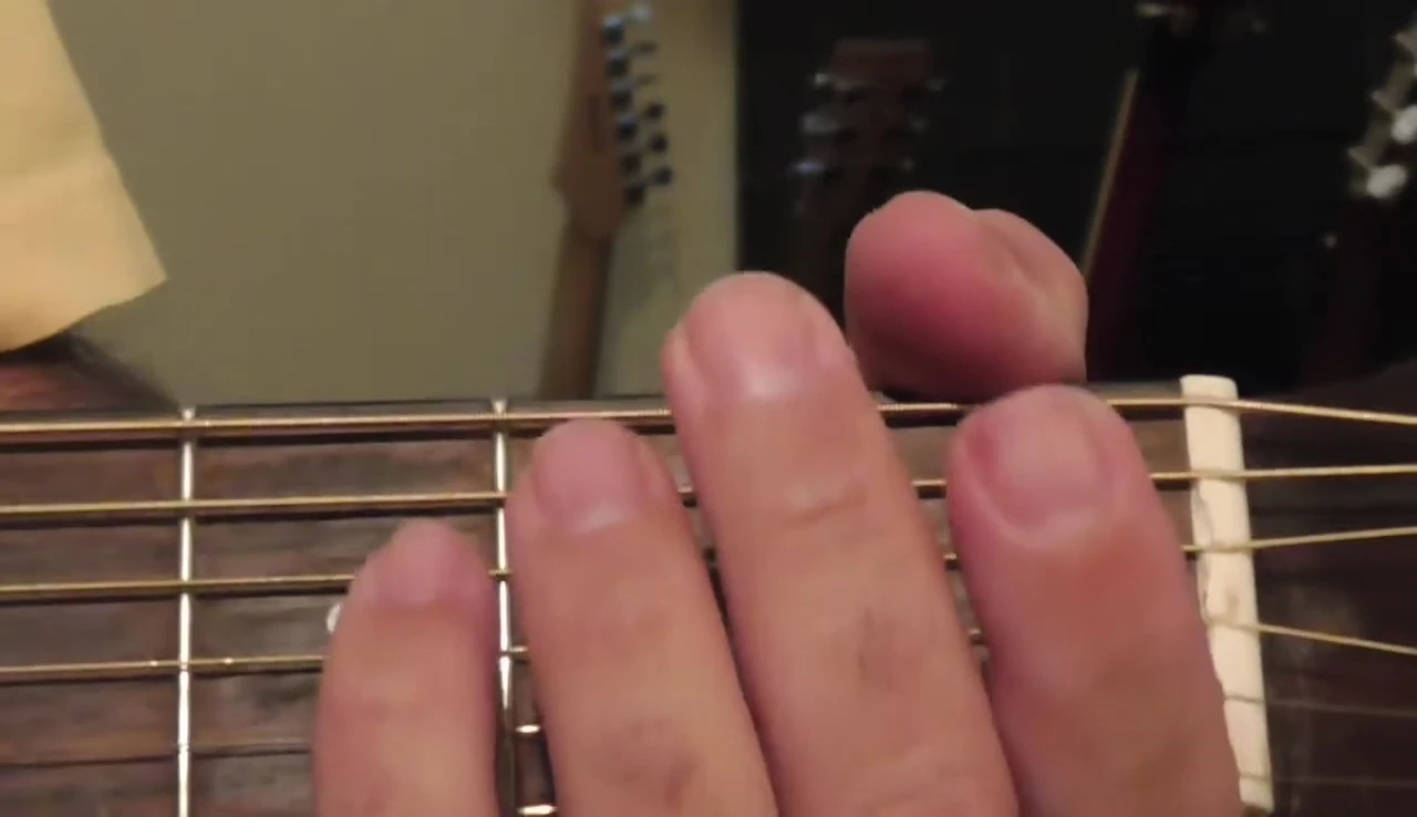 Close-up of the reviewer's hands playing the Ernie Ball strings.