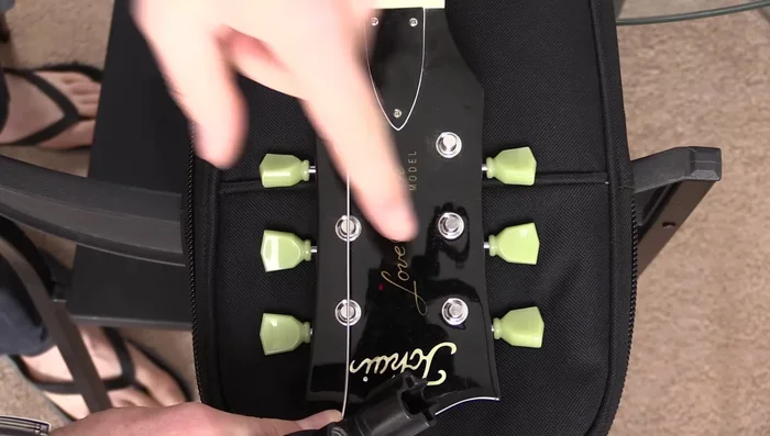 Measure the distance between the bridge and one tuner. Drop the string back by that distance.