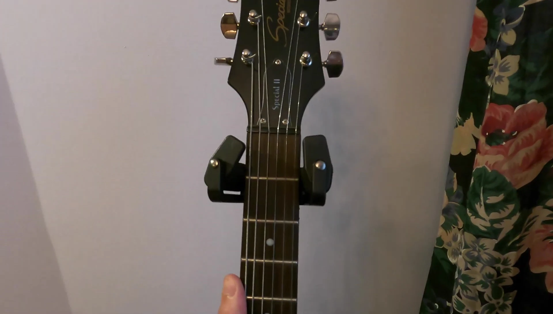 The guitar securely held by the neck hug