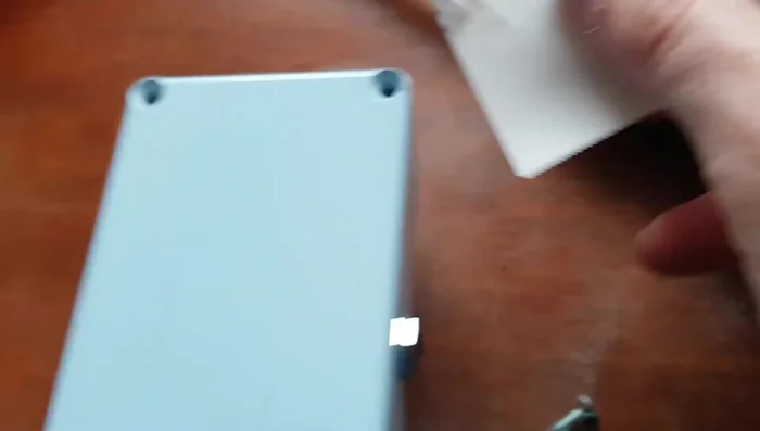 Use the thin object as a lever to pry the battery loose, applying steady and even pressure.