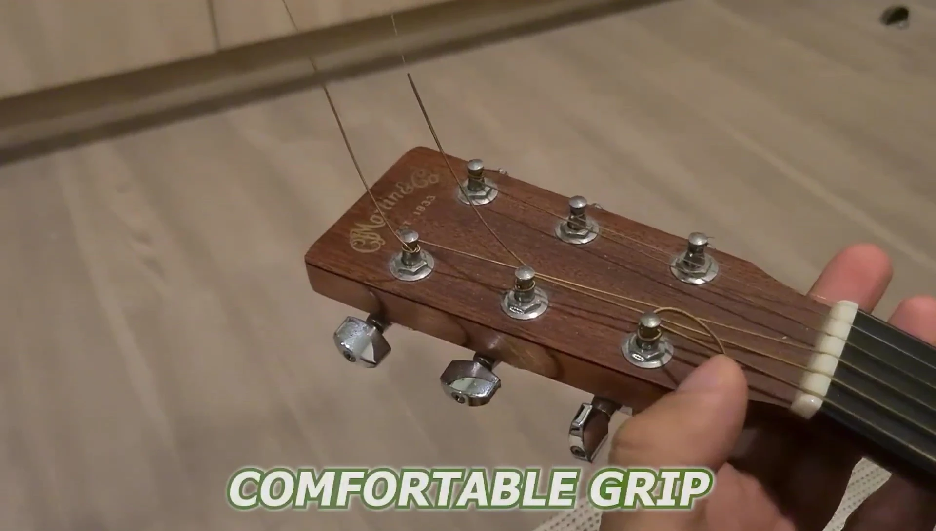 Hand comfortably gripping the D'Addario Pro Winder while winding a string.