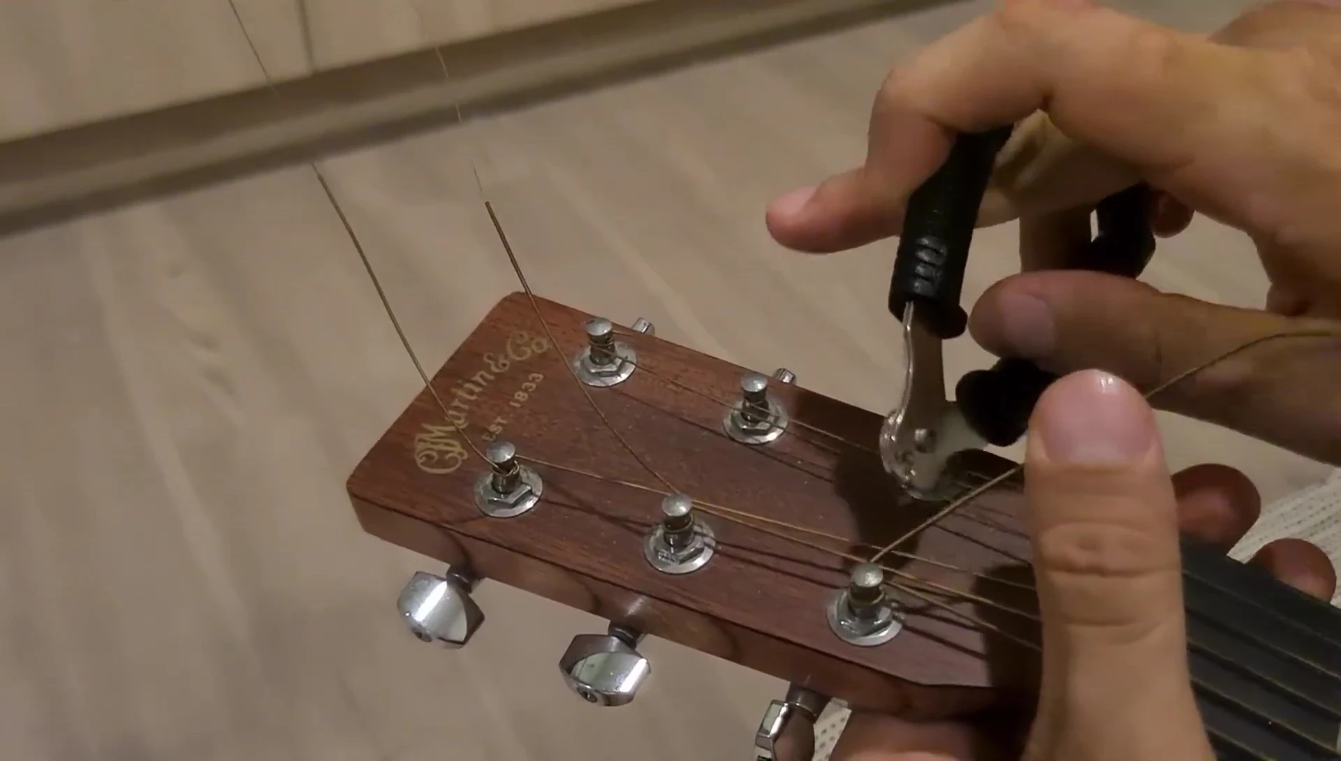 Demonstrating the use of the built-in ratchet mechanism for efficient string winding.
