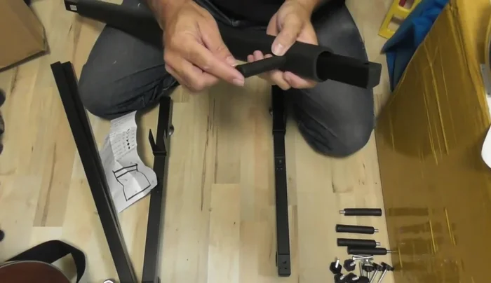 Attach the two upright support pieces to the base pieces using the pegs. Note that the included plastic caps might spin freely; applying pressure to the center metal piece while turning is necessary to secure them.