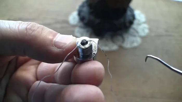 Use a flat pick or similar tool to help guide the floss loop under the screw head.