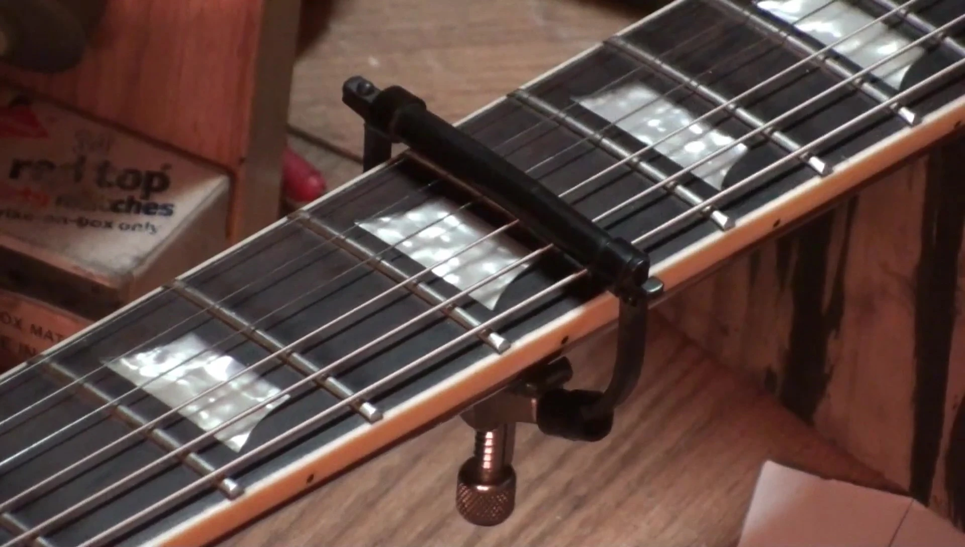Demonstrating the quick release feature on a capo.