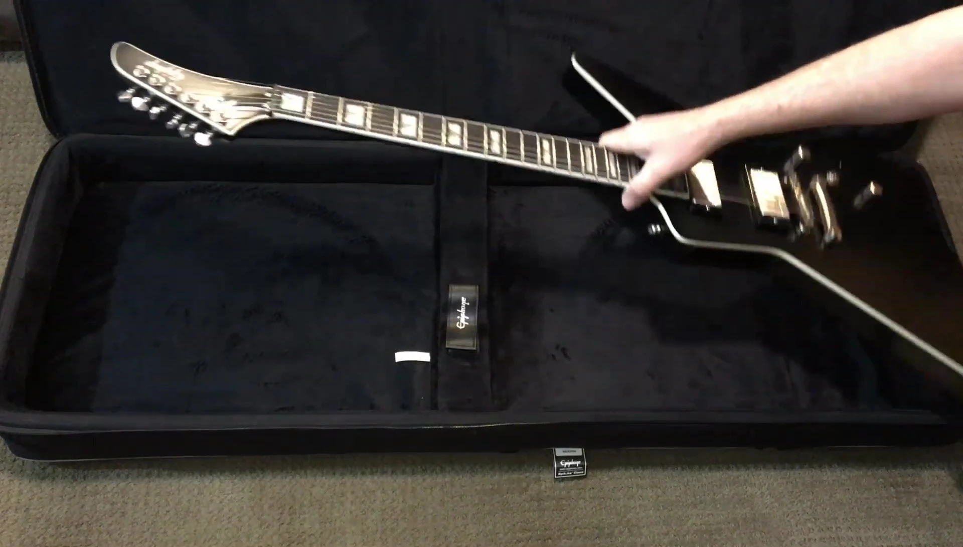 The guitar being placed in the case
