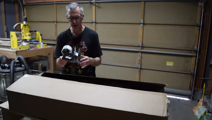 Attach the shipping label to the side of the box, maintaining the body-at-the-bottom orientation for safer transit.