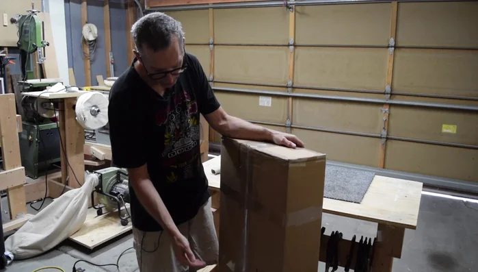 Attach the shipping label to the side of the box, maintaining the body-at-the-bottom orientation for safer transit.