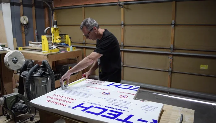 Carefully cut out the traced shape from the foam insert, ensuring the cut is slightly inside the traced line for a precise fit. Use a spray paint can wrapped in sandpaper to gently shape the neck contour on the foam.