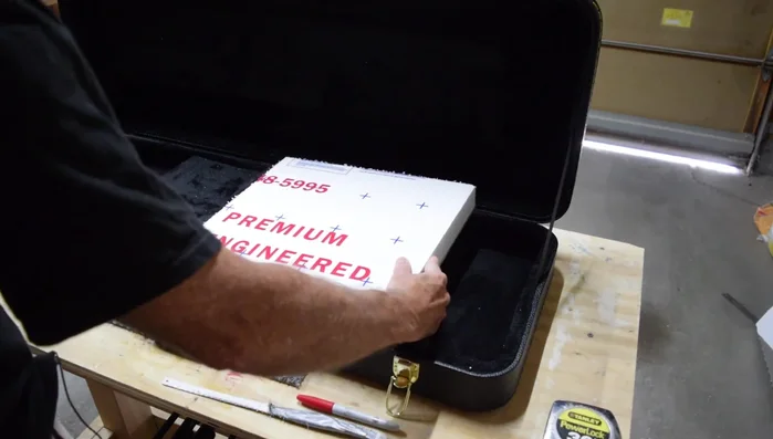 Carefully cut out the traced shape from the foam insert, ensuring the cut is slightly inside the traced line for a precise fit. Use a spray paint can wrapped in sandpaper to gently shape the neck contour on the foam.