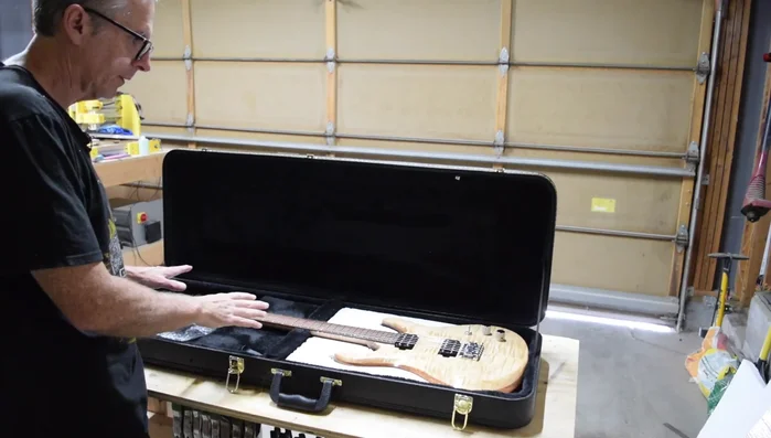 Place the guitar into the hardshell case, ensuring it's firmly seated in the foam insert. Close the case.