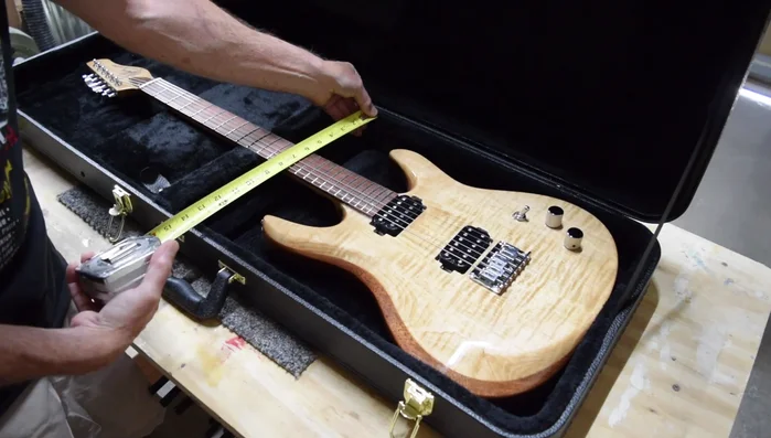 Carefully cut out the traced shape from the foam insert, ensuring the cut is slightly inside the traced line for a precise fit. Use a spray paint can wrapped in sandpaper to gently shape the neck contour on the foam.