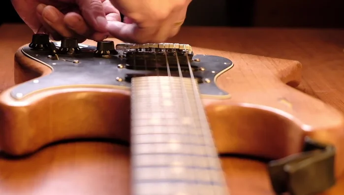 Repeat steps 4 and 5 until the desired string height is achieved. The speaker makes several small adjustments to his B and E strings.