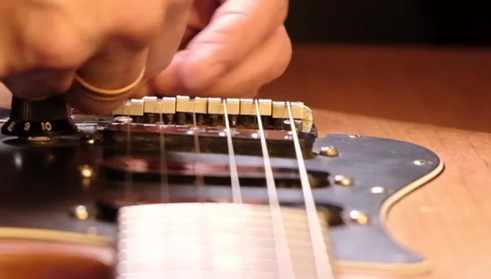 Repeat steps 4 and 5 until the desired string height is achieved. The speaker makes several small adjustments to his B and E strings.