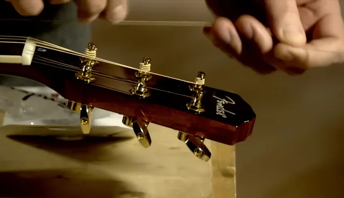 Repeat steps 8-10 for the remaining strings, but thread the strings from the opposite side of the headstock for the other three strings. Remember to wind the unwound strings with the first winding above and the second below the string on the peg.