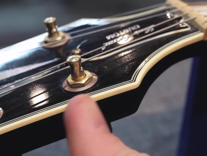 Bring the other end of the string to the headstock and feed it through the tuner hole. Avoid excessive windings around the tuners.