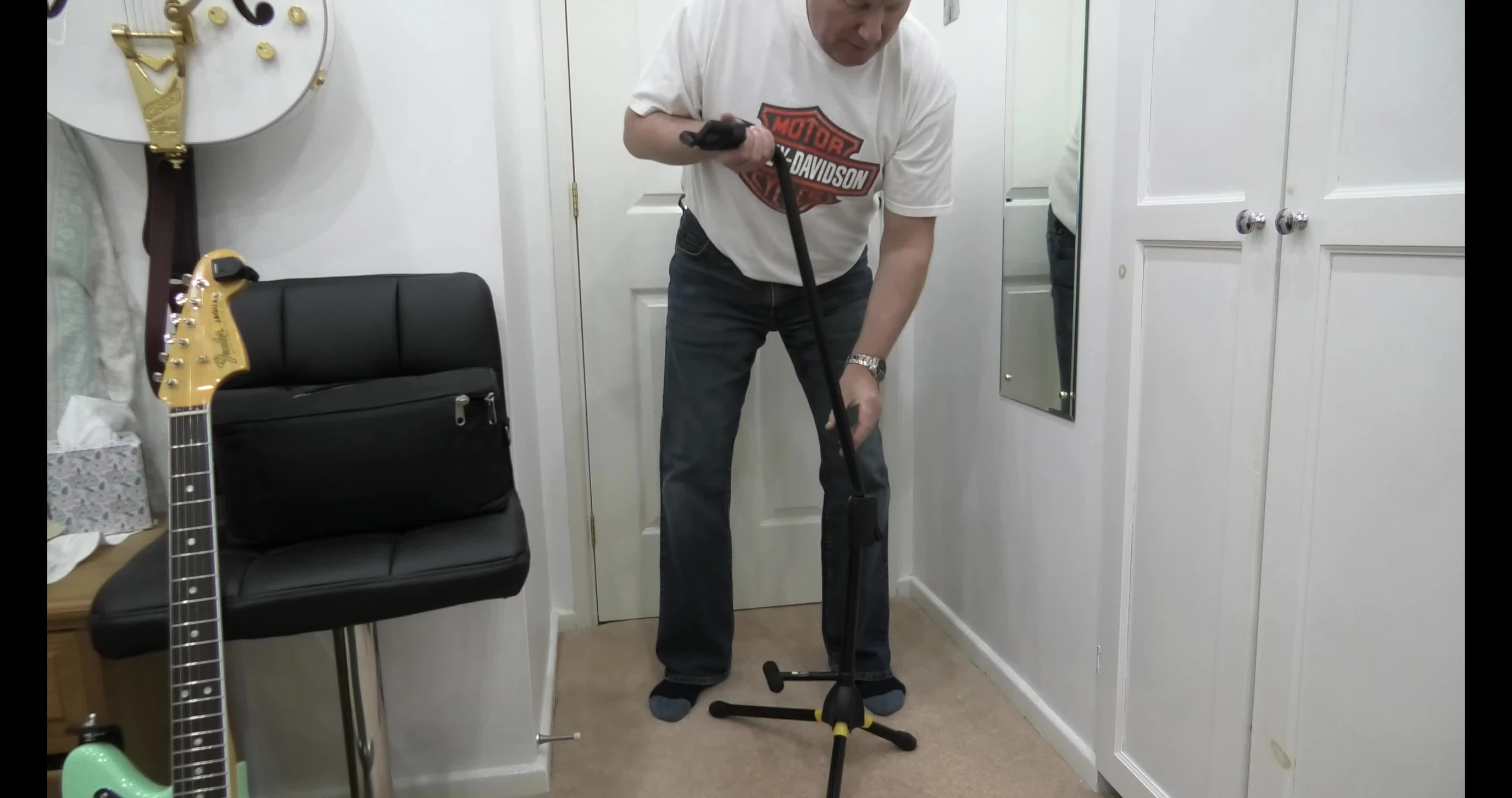 Positioning the frame of the stand against the guitar.